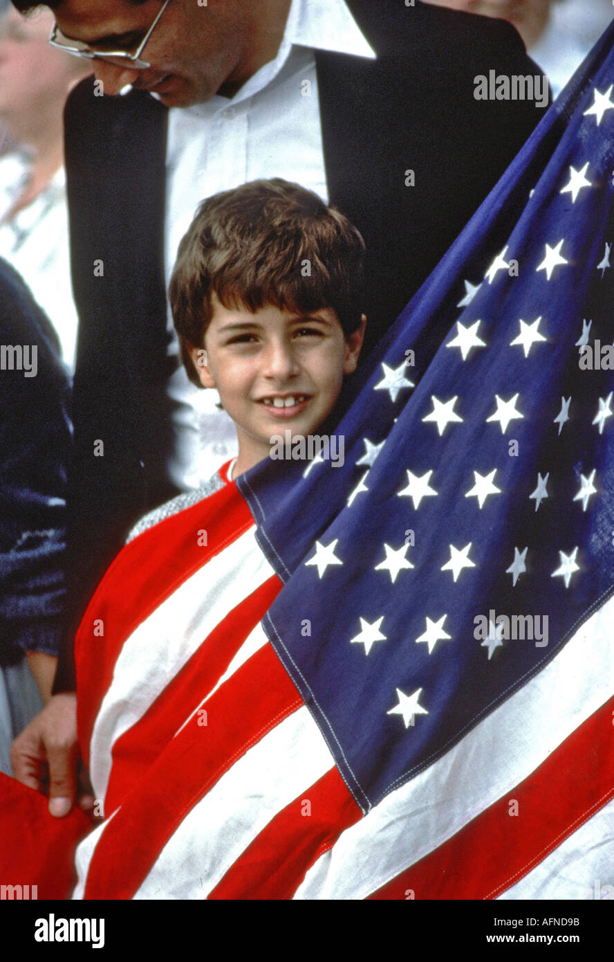 Ragazzo avvolto nella Bandiera americana dimostra il suo sentimento patriottico Foto Stock