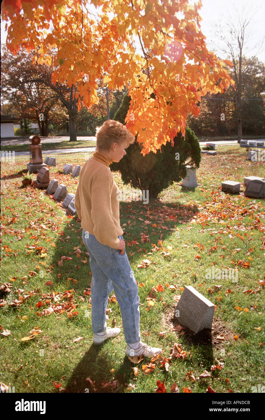 Visite femmina un luogo di sepoltura in un cimitero Foto Stock