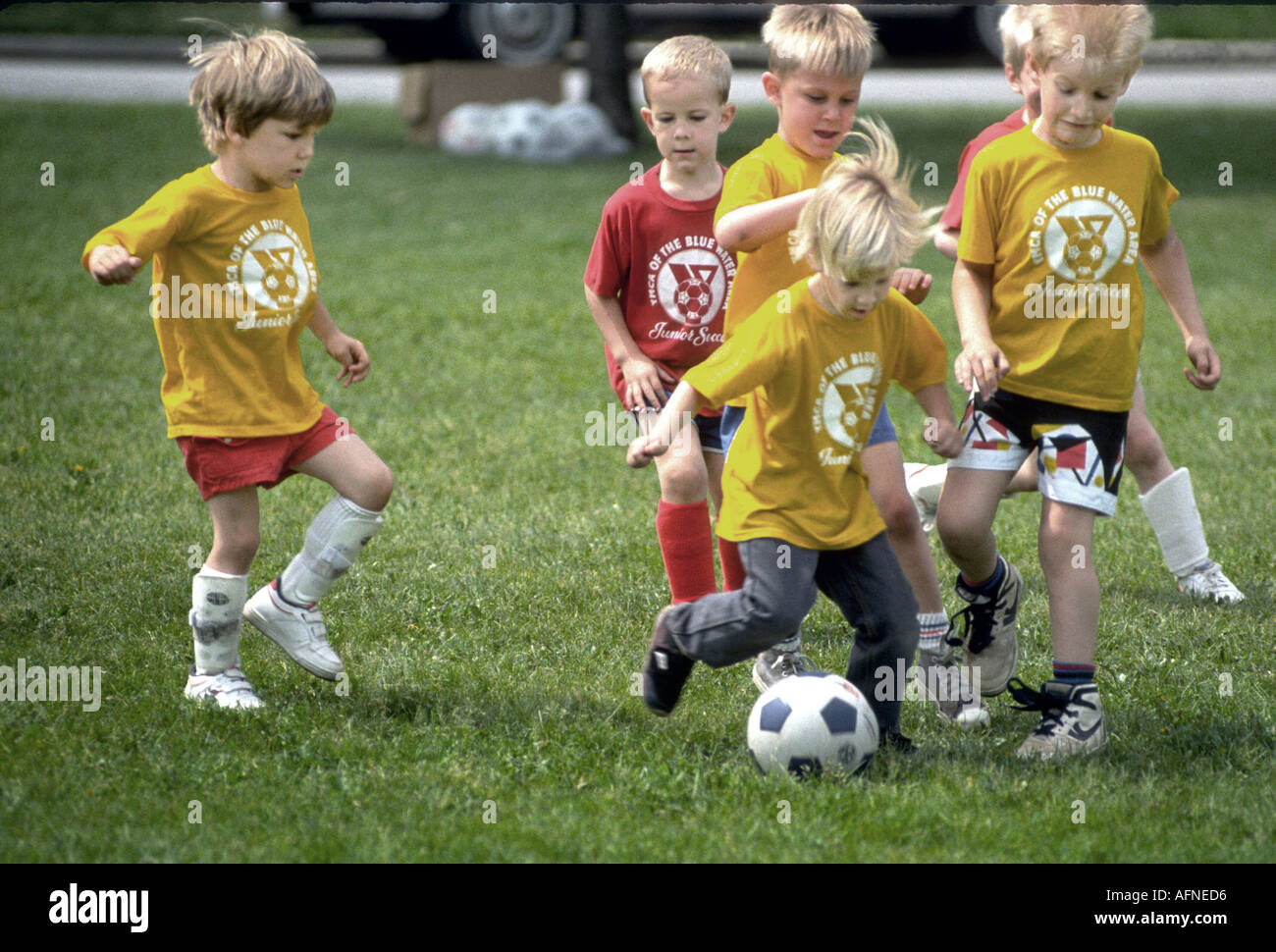 4 e 5 anni i ragazzi e le ragazze giocare a calcio Foto Stock