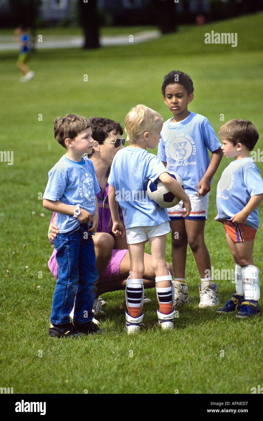 4 e 5 anni i ragazzi e le ragazze giocare a calcio Foto Stock