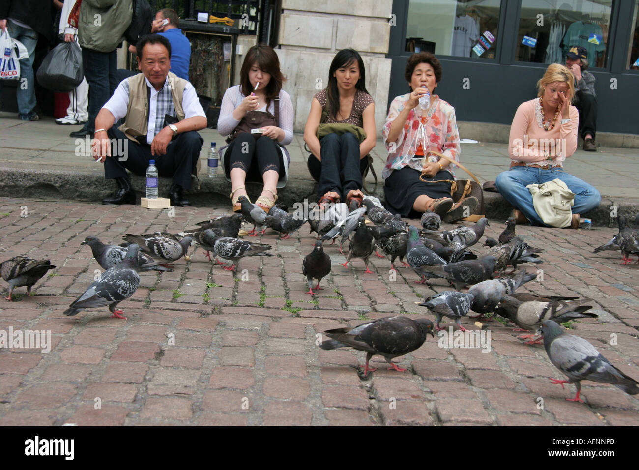 I turisti di mangiare con piccioni, Covent Garden, Londra Foto Stock