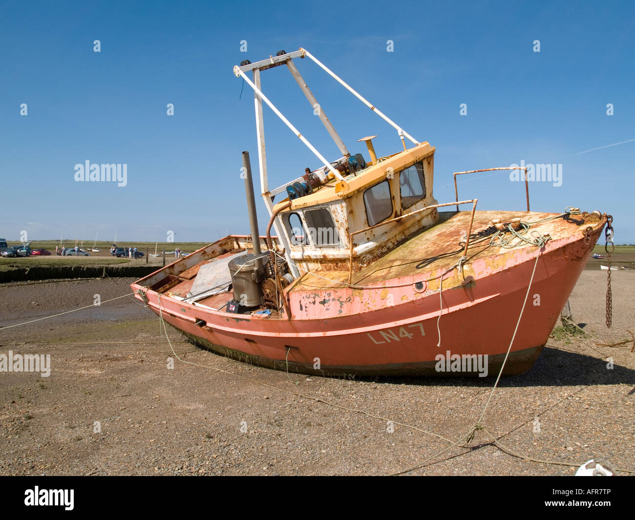 Una barca da pesca appoggia su una banca di ciottoli, Brancaster Staithe, Norfolk, Regno Unito Foto Stock
