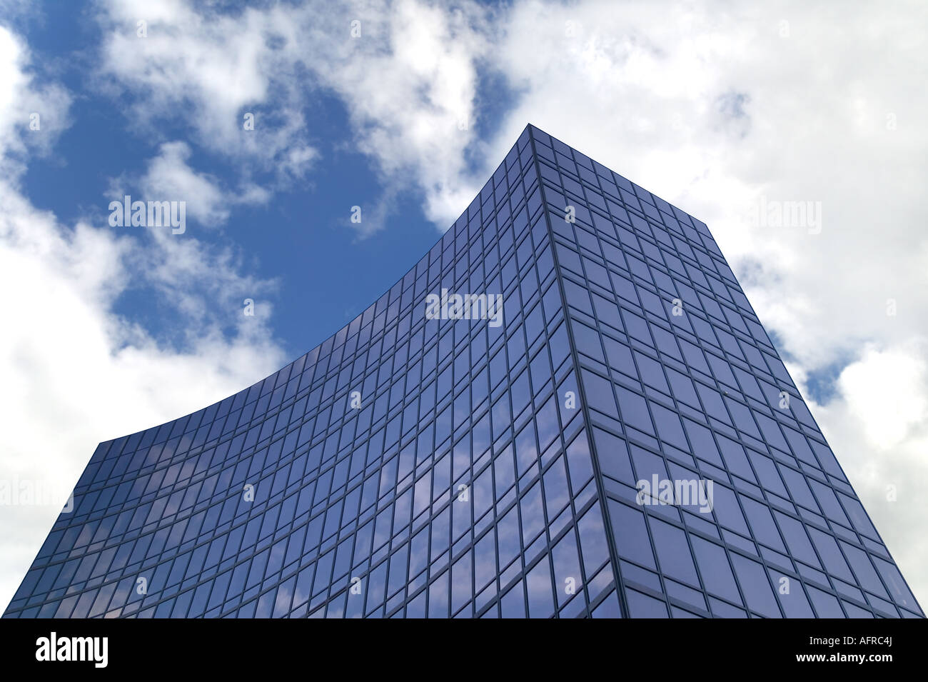 Moderno vetro affumicato ufficio edificio contro un blu cielo nuvoloso Foto Stock