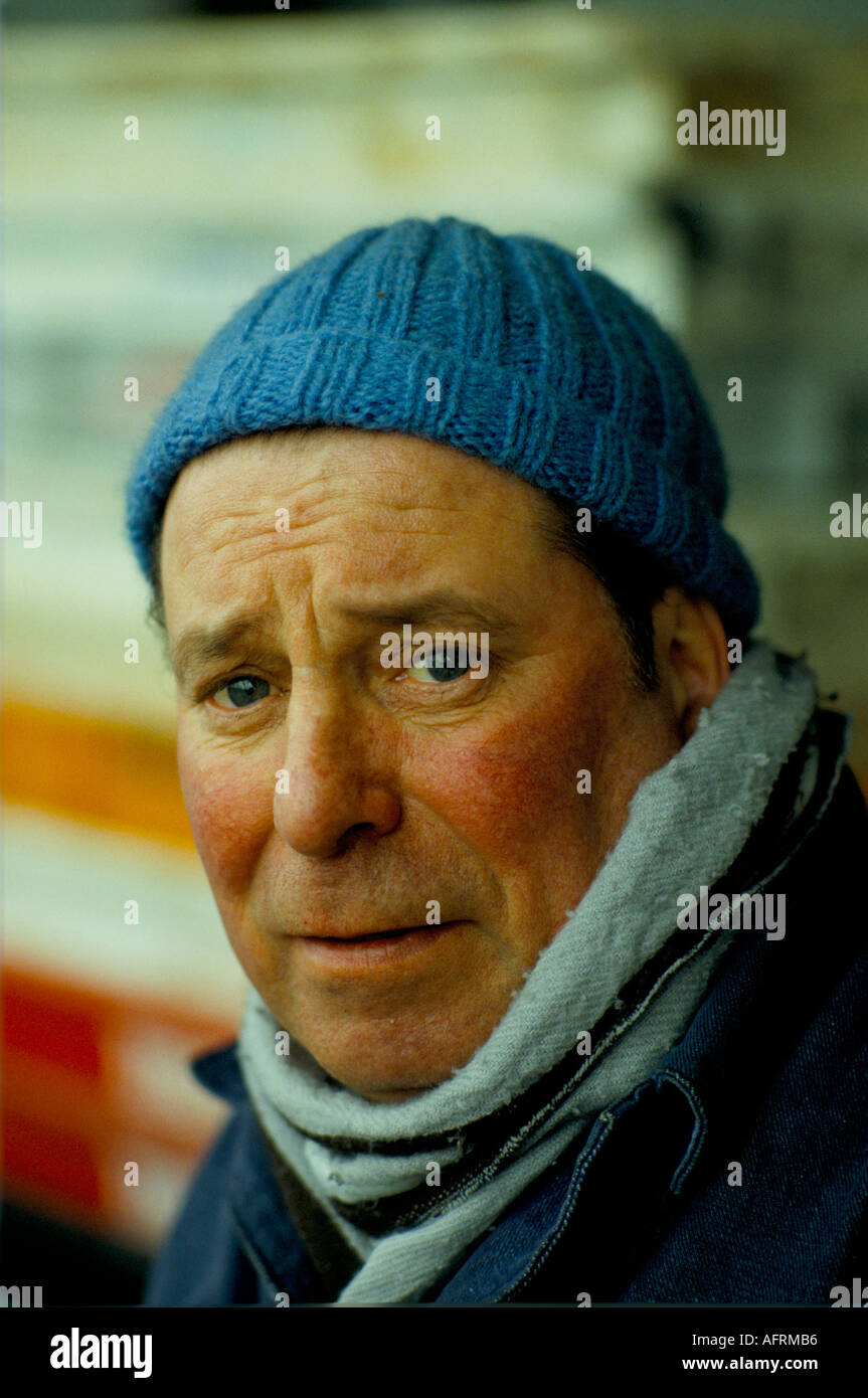Uomo che sembra triste freddo e indossa un cappello fatto in casa in maglia di lana, un lavoratore portuale all'Albert Docks. 1980s 1980s UK HOMER SYKES Foto Stock