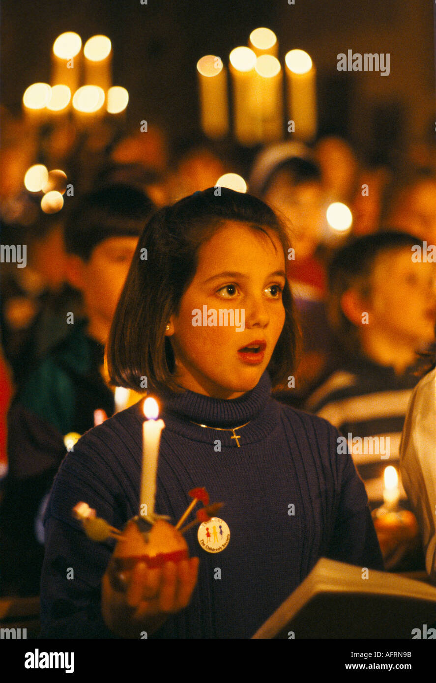 Christingle Christmas Church carol Service bambini che cantano. Studentessa adolescente che tiene le candele accese con Leighton Buzzard arancione anni '1990 UK HOMER SYKES Foto Stock