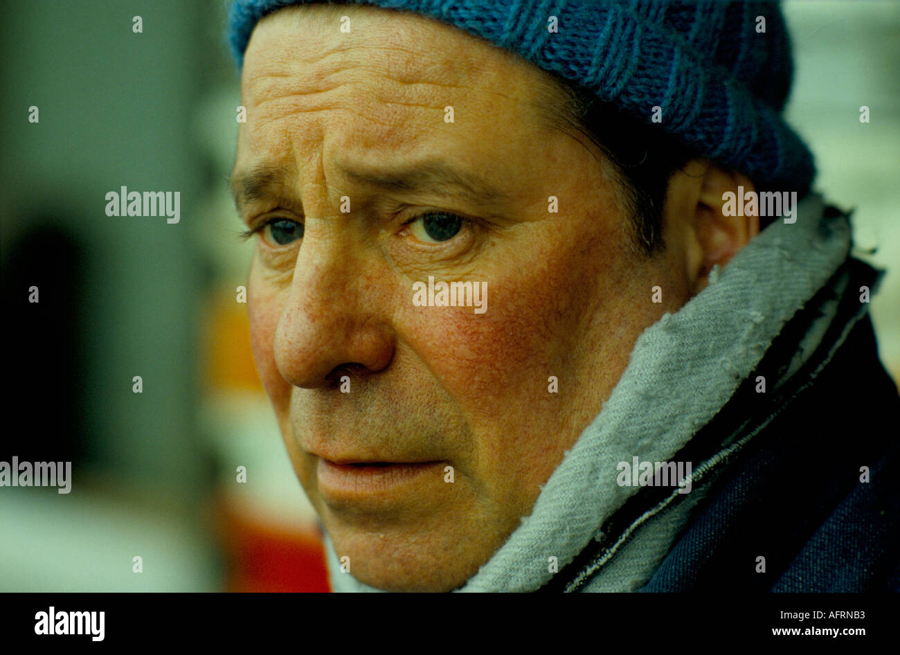 Uomo che sembra triste freddo e indossa un cappello fatto in casa in maglia di lana, un lavoratore portuale all'Albert Docks. 1980s 1980s UK HOMER SYKES Foto Stock