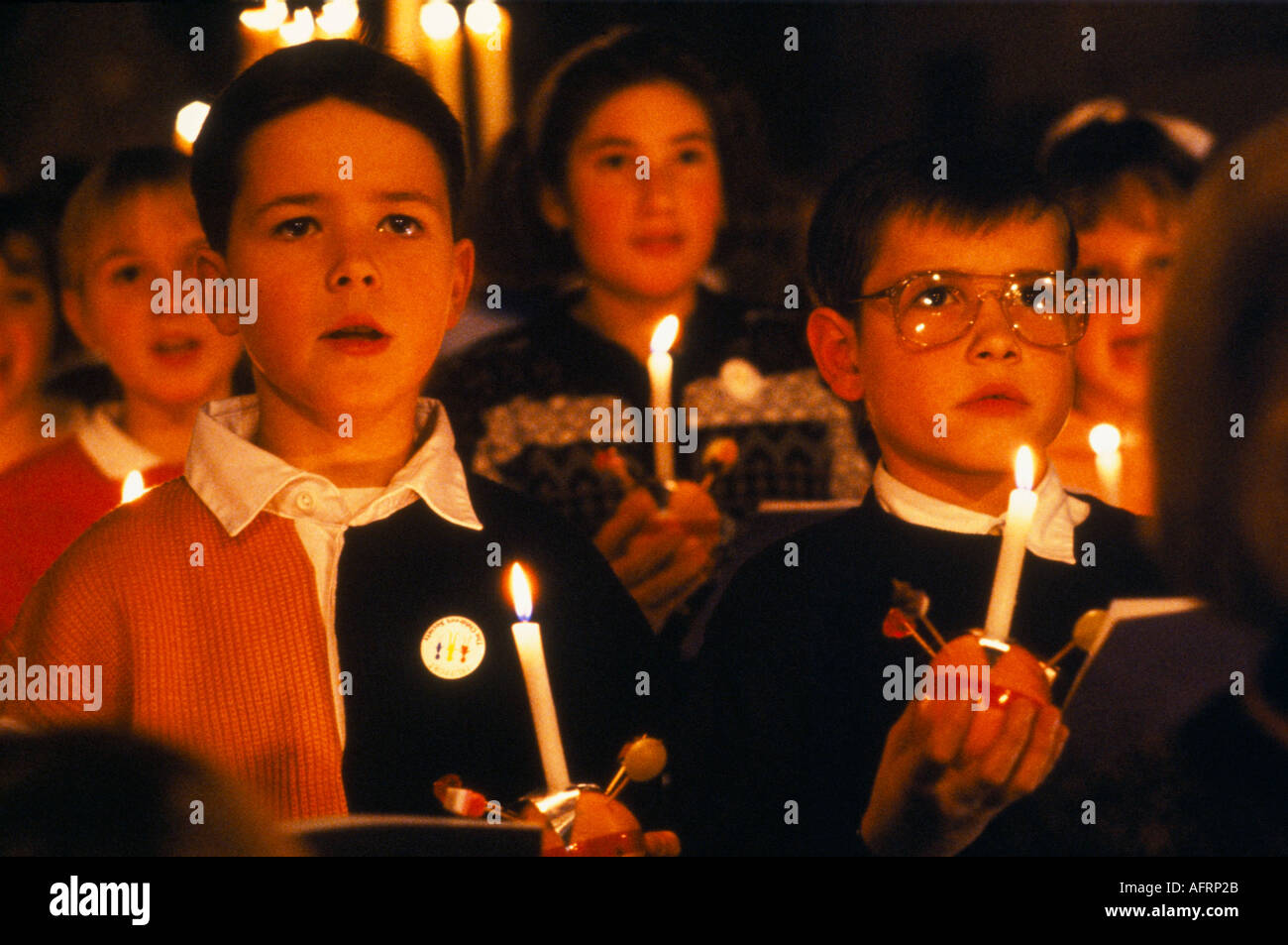 Christingle Christmas Church carol scuola di servizio bambini coro cantare. Tenere accese candele con arancio Leighton Buzzard 1990 Regno Unito HOMER SYKES Foto Stock