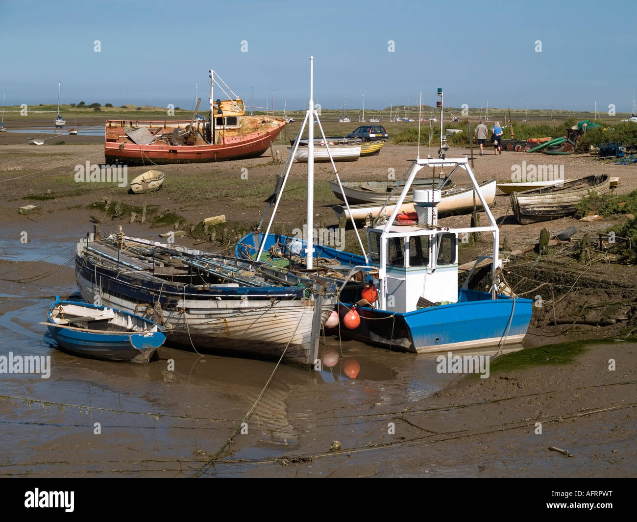 Barche da pesca resto sul fango a bassa marea Brancaster Staithe NORFOLK REGNO UNITO Foto Stock