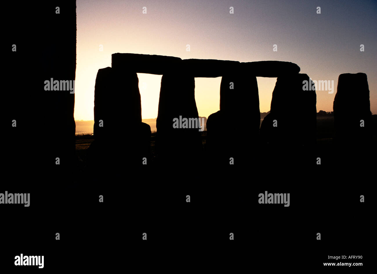 L'alba, il sole a Stonehenge si staglia contro un cielo limpido del mattino presto. Wiltshire Inghilterra 21 giugno Midsummer Salisbury Plain Regno Unito HOMER SYKES Foto Stock