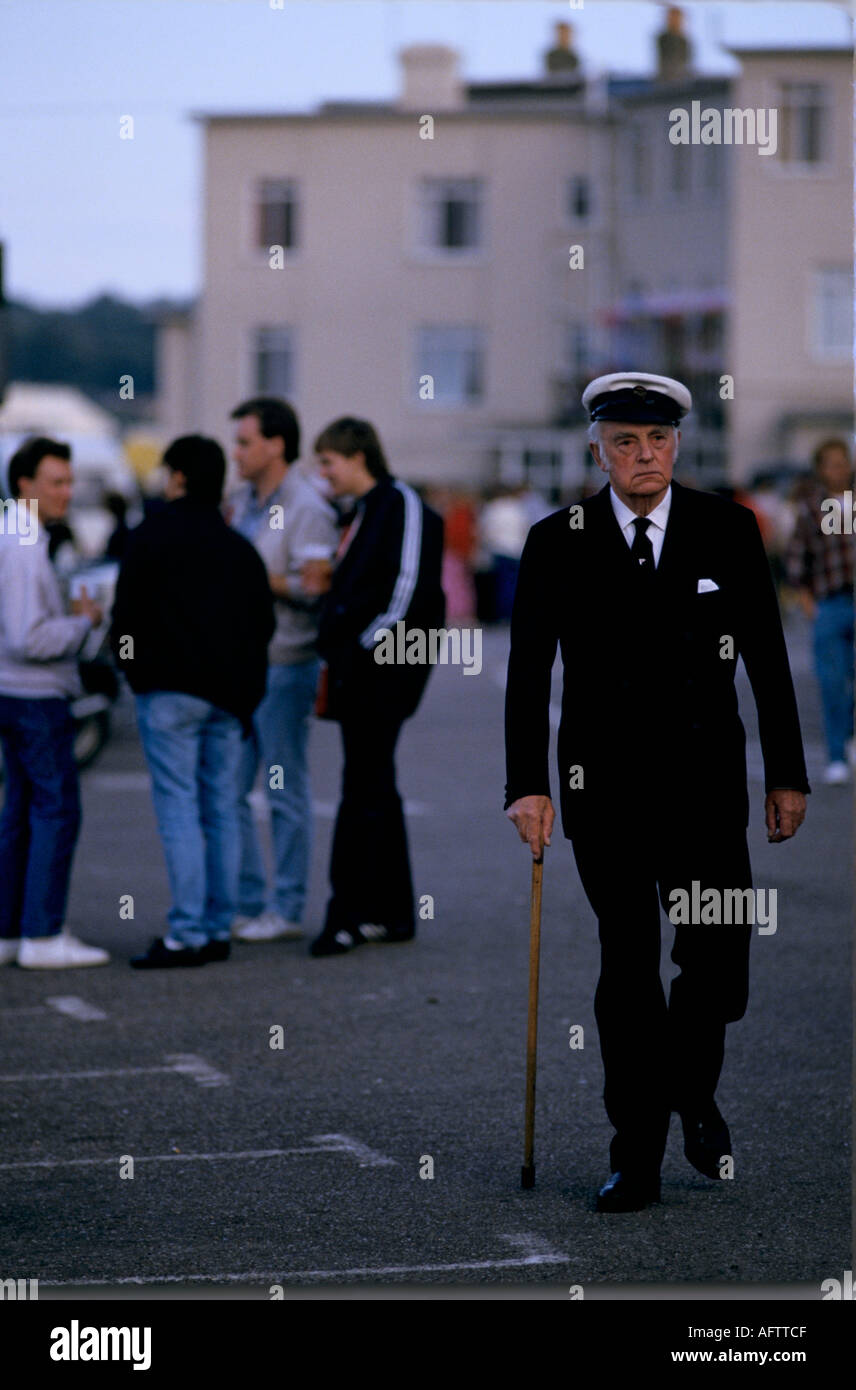 Cowes Week 1980s Regno Unito. Un vecchio marinaio anziano che usa bastone da passeggio nella sua uniforme navale. Cowes Regatta, Isola di Wight, Hampshire Regno Unito 1985 HOMER SYKES Foto Stock