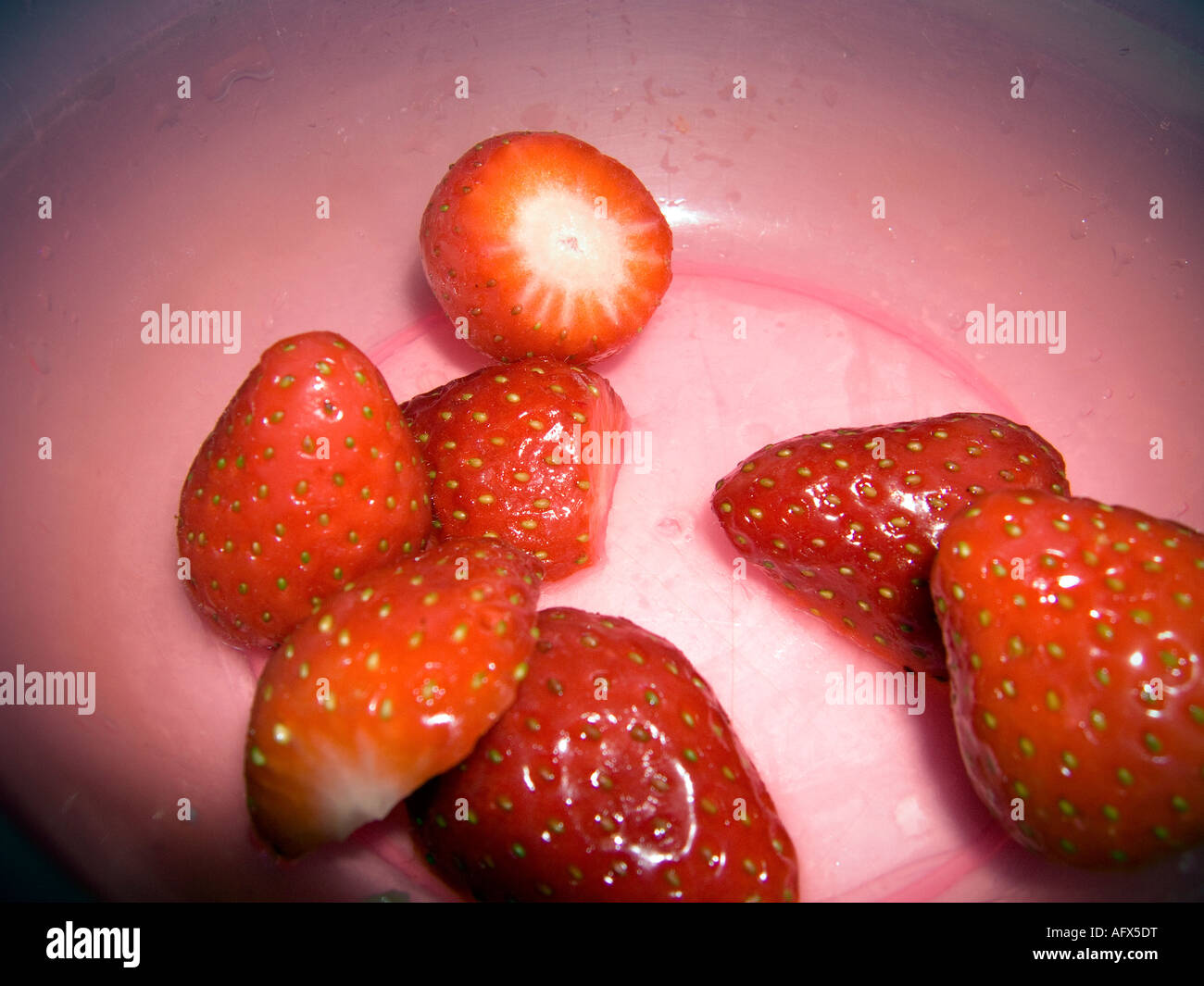 Le fragole in un recipiente rosa Foto Stock