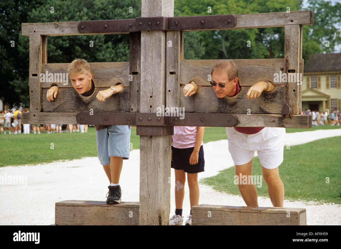 COLONIAL WILLIAMSBURG Virginia STATI UNITI D'AMERICA AGOSTO uomo e suo figlio nelle scorte al di fuori del Palazzo di Giustizia Foto Stock