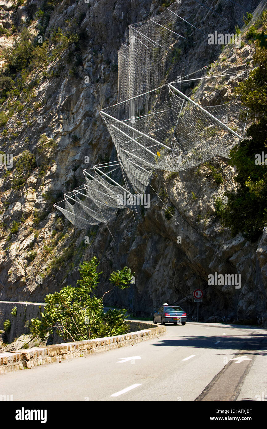 Lavoro a rete di filo usato per arrestare la caduta di sassi sulla strada nelle Alpes Maritimes, Francia Foto Stock