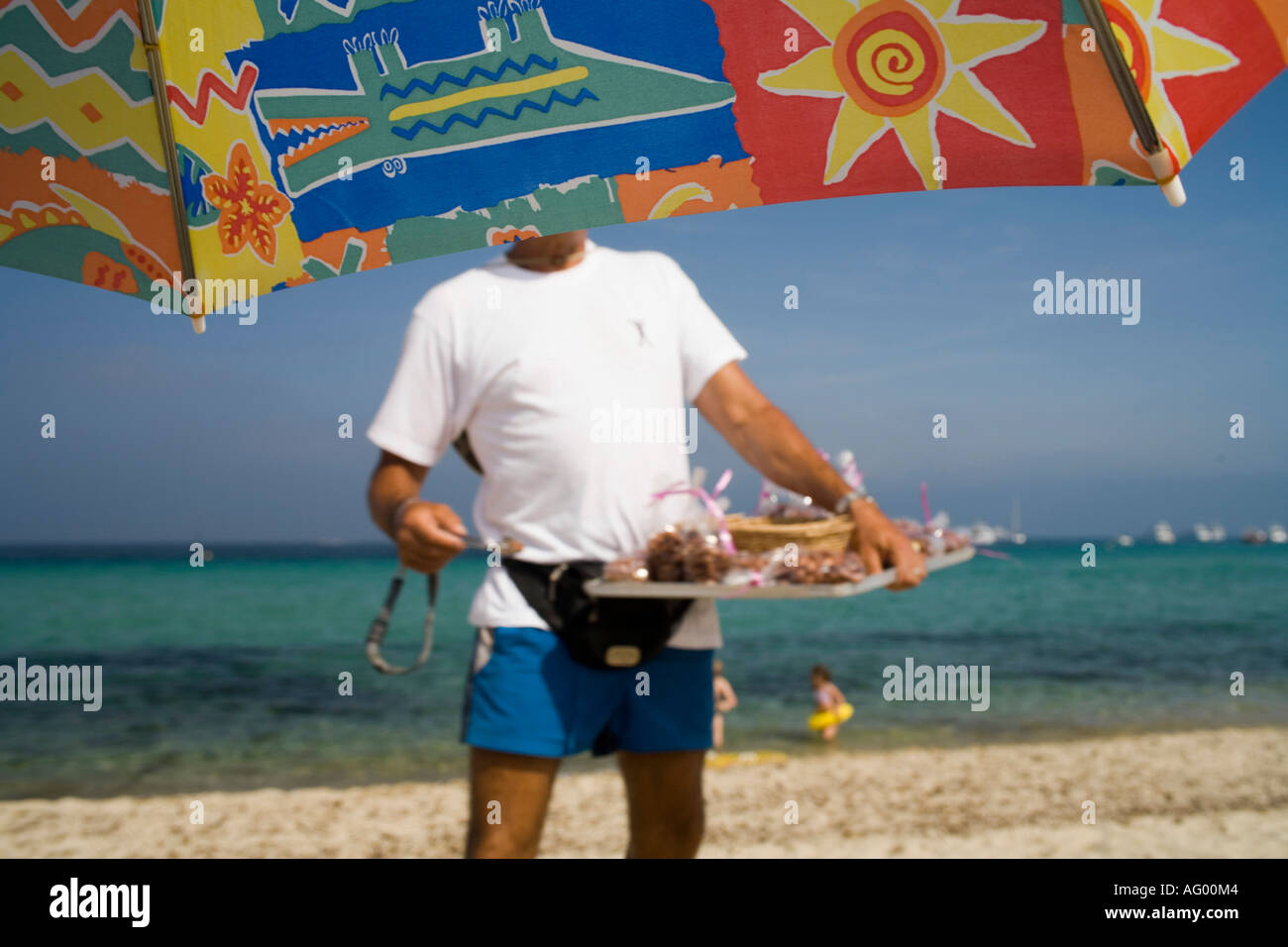 Plage de Pampelonne - St Tropez, Francia. vista incorniciata da sunumbrella. l uomo vendono dolci sulla spiaggia Foto Stock