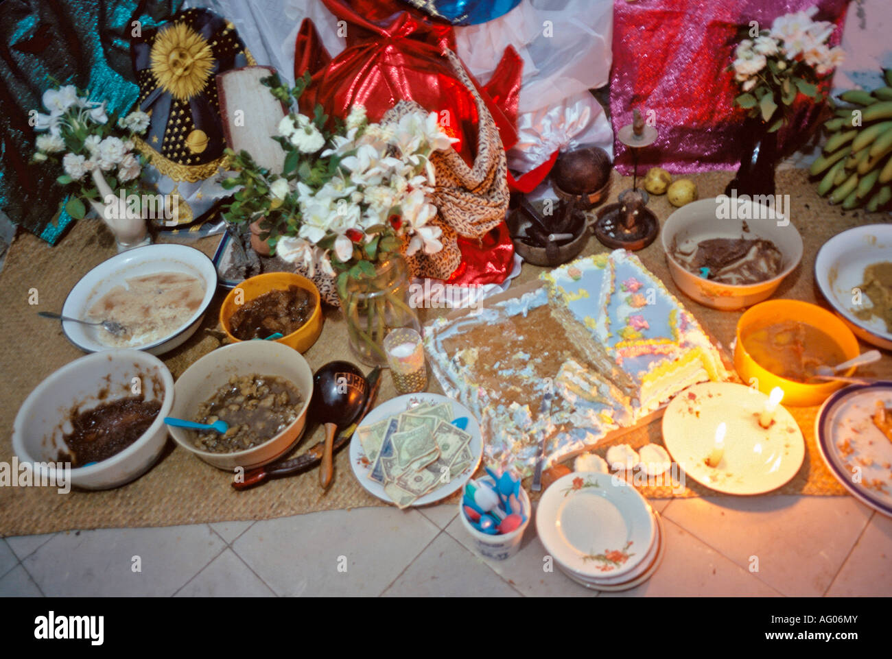 Offerte di religiose di soldi e cibo al di sotto di una Santeria altare in una casa a los Pinos sezione di Havana Cuba Foto Stock
