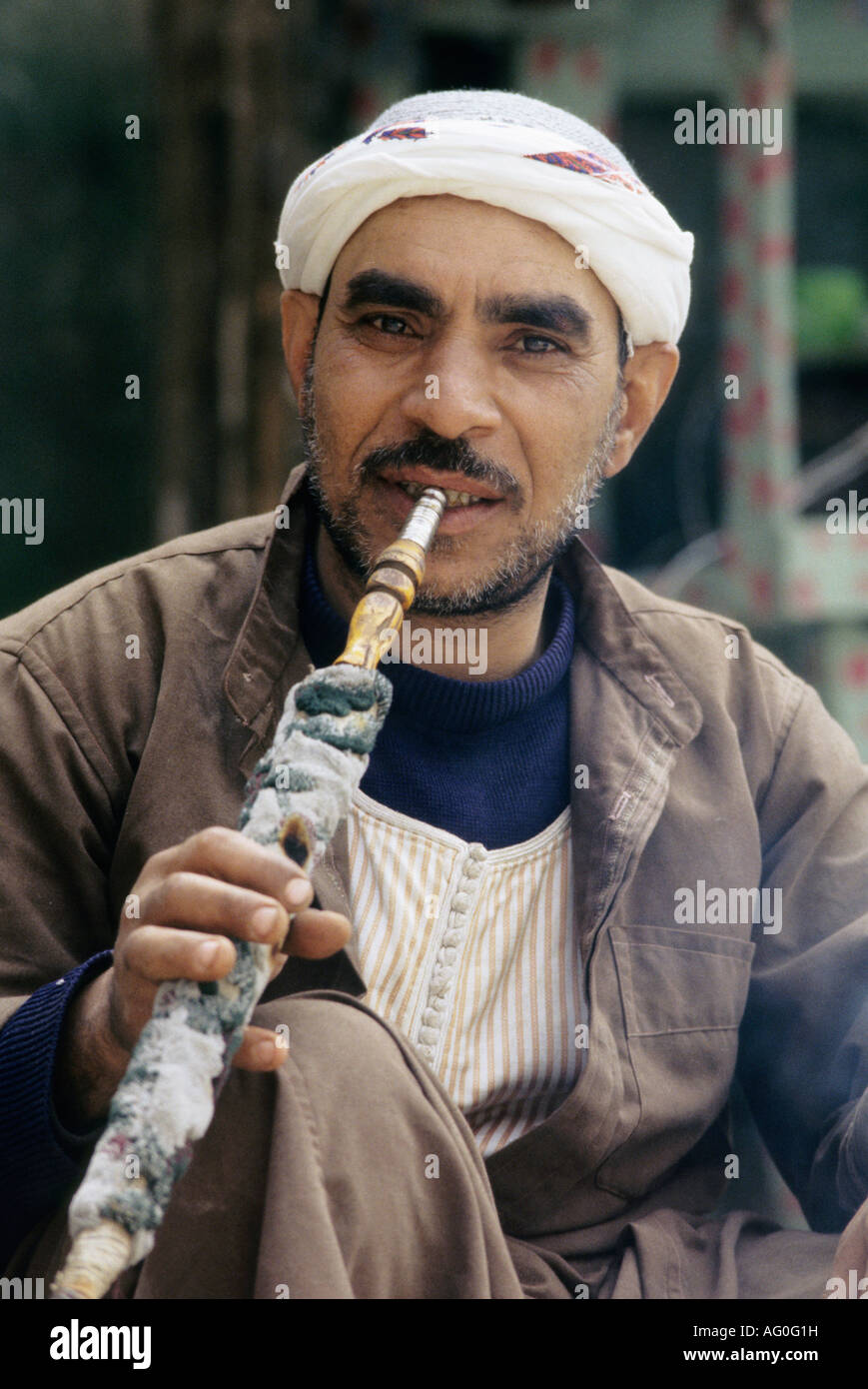 Uomo egiziano Narguile fumare in Khan El Khalil market Cairo Egitto Foto Stock