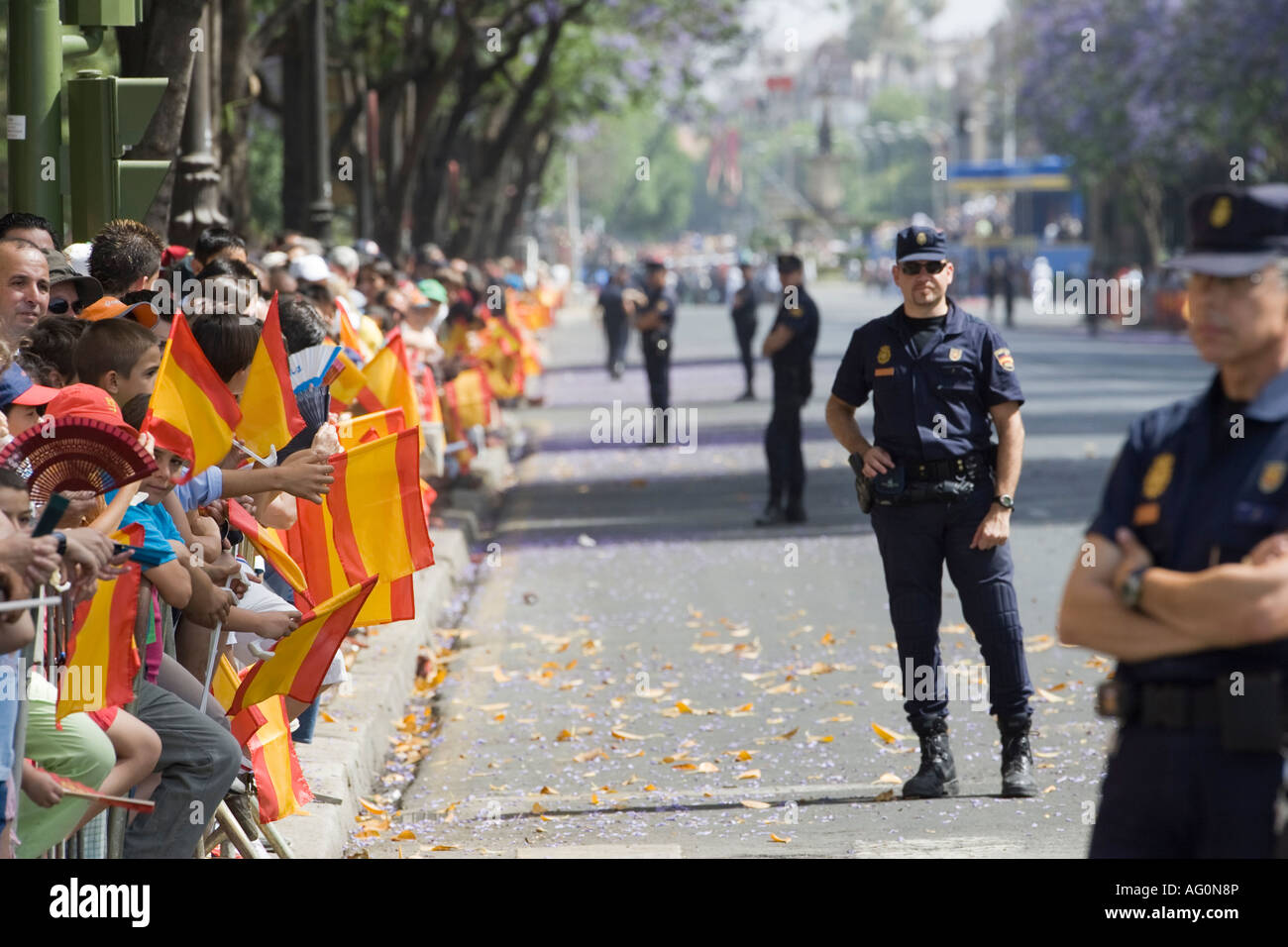 Persone su strada con bandiere spagnole in attesa per la parata Foto Stock