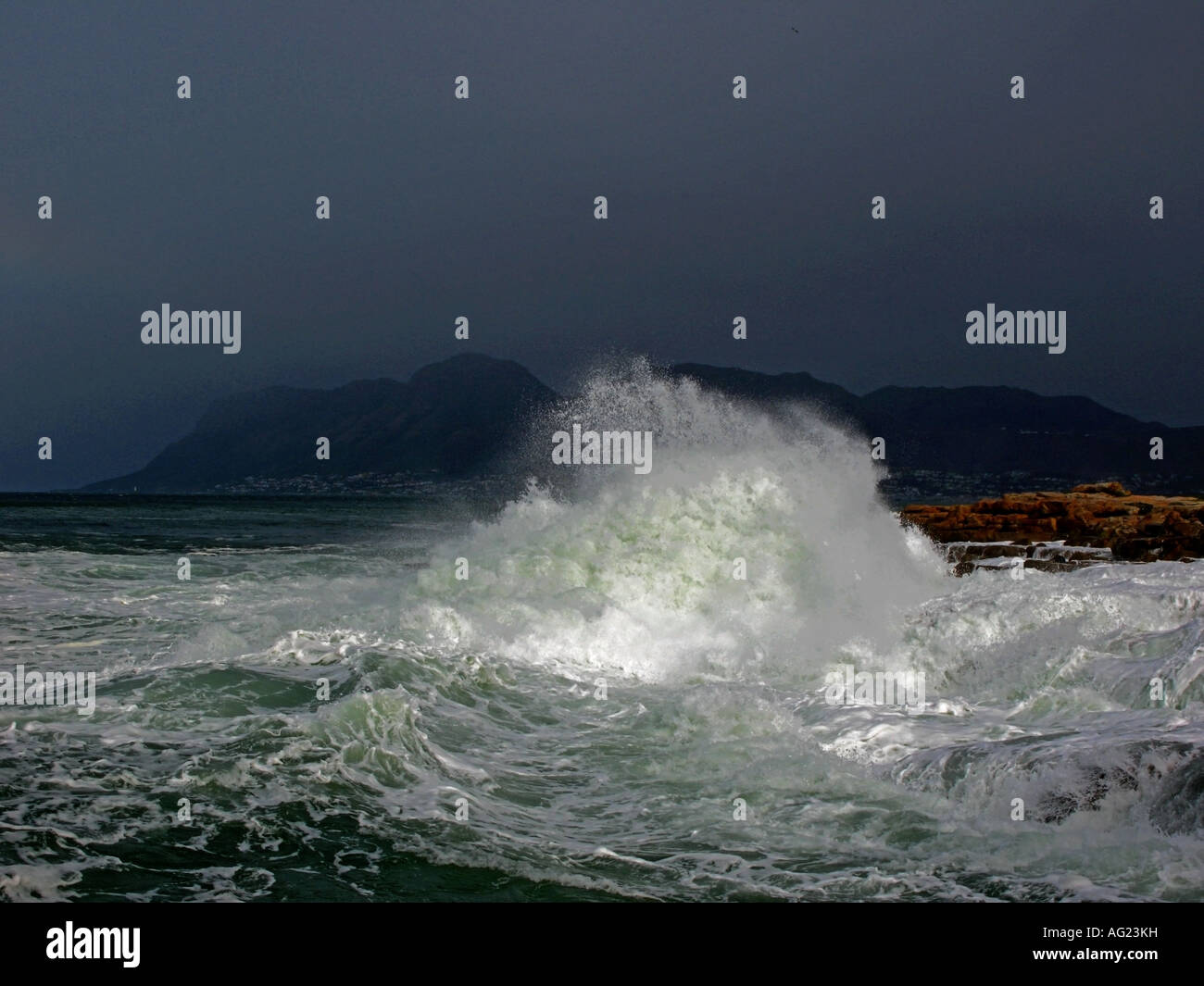 Una tempesta in mare causa il surf di costruire e cancelletto su rocce in False Bay a Kalk Bay a Città del Capo in Sud Africa Foto Stock