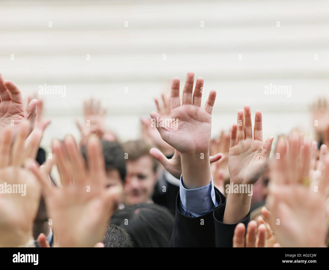 La folla di persone che allevano le mani, concentrarsi sulle mani Foto Stock