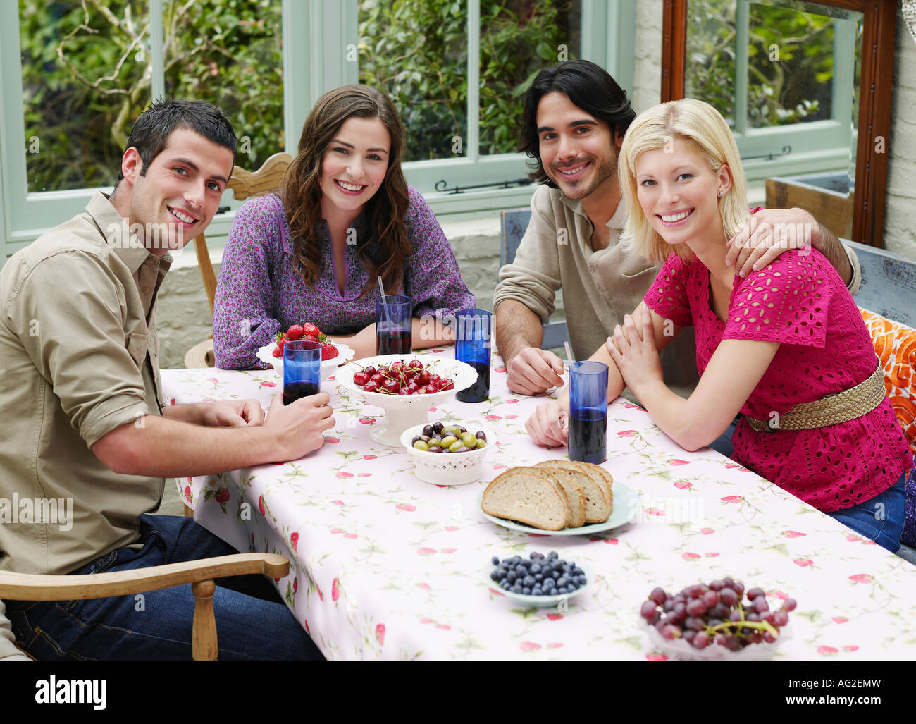 Un gruppo di giovani seduti al tavolo della veranda, vista in elevazione, ritratto Foto Stock