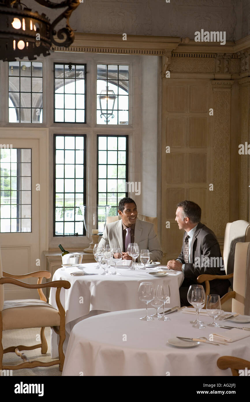 Due uomini di affari seduti al ristorante tavolo parlando Foto Stock