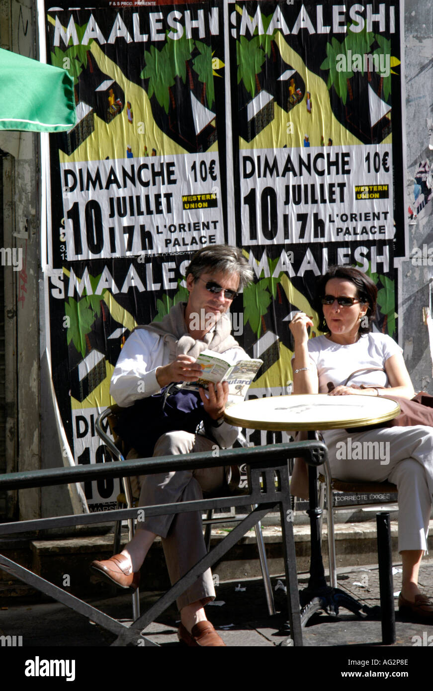 In Francia il mercato di Marsiglia in Marche des cappucini Noailles Area è fortemente Arab sotto un poster di sedersi un paio di turisti parigina Foto Stock