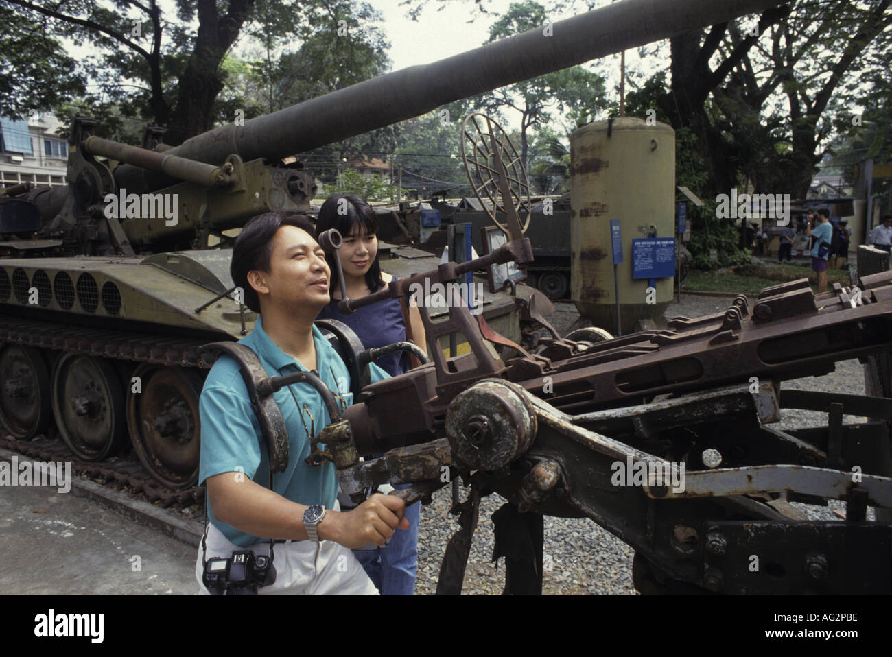 Un visitatore al museo della guerra nella città di HoChiMinh gioca con una mostra Foto Stock