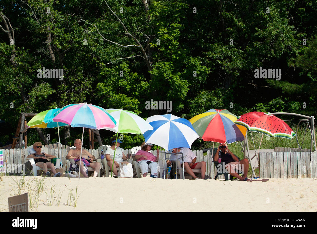 Colorato ombrelloni a proteggere i cittadini anziani in un momento di relax a Sleeping Bear Dunes National Seashore Michigan Foto Stock