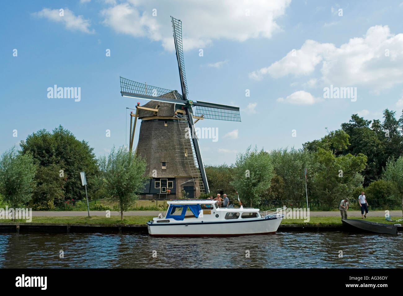 Il mulino a vento di paglia e motoscafo sul fiume Amstel Holland Europa Foto Stock