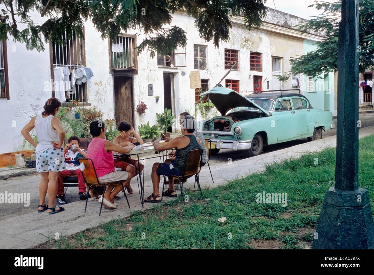 La famiglia gioca domino davanti alla loro casa in El Cerro, Havana, Cuba Foto Stock