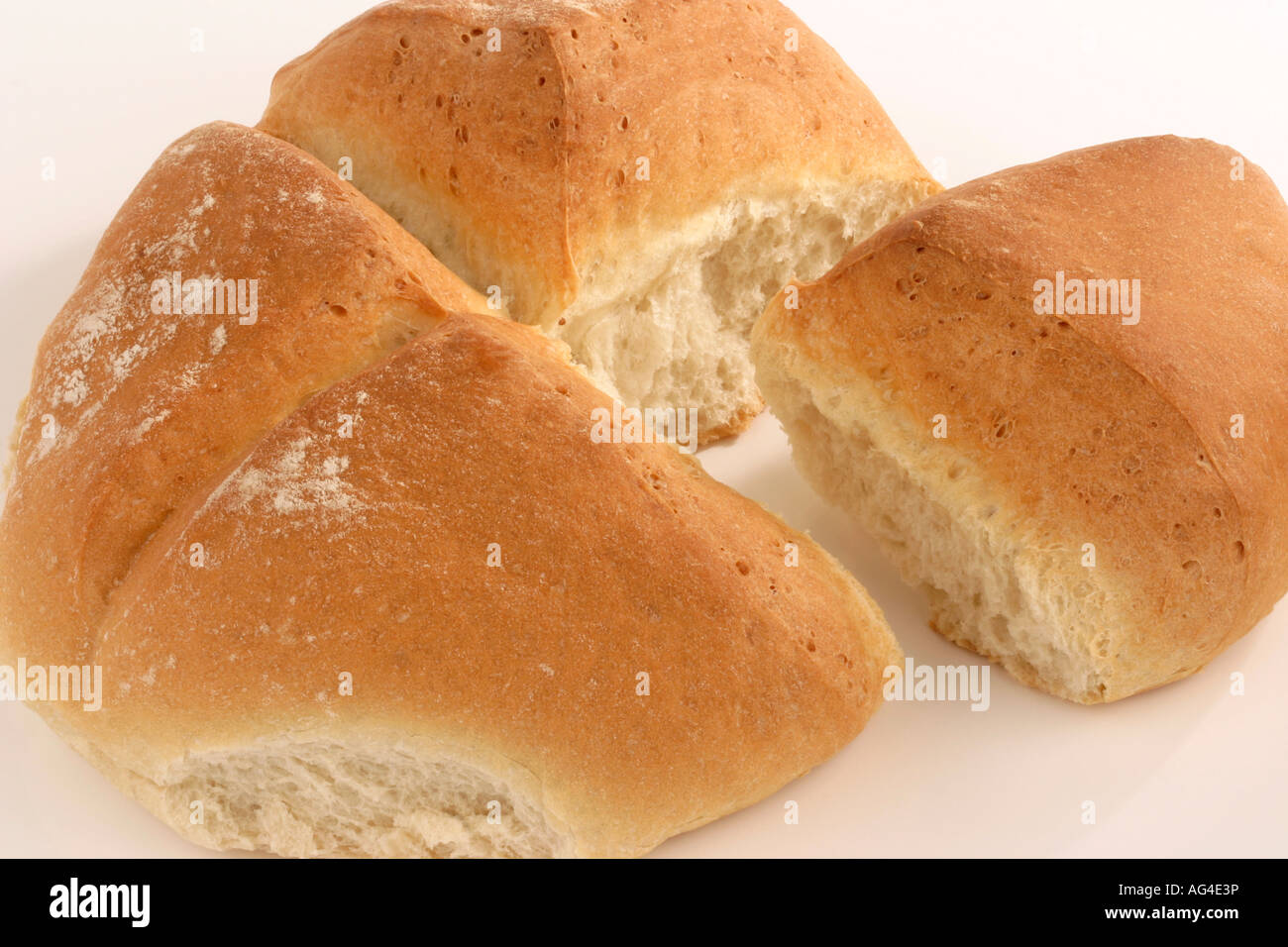 Una pagnotta di pane diviso in quattro quarti con un singolo pezzo strappato Foto Stock