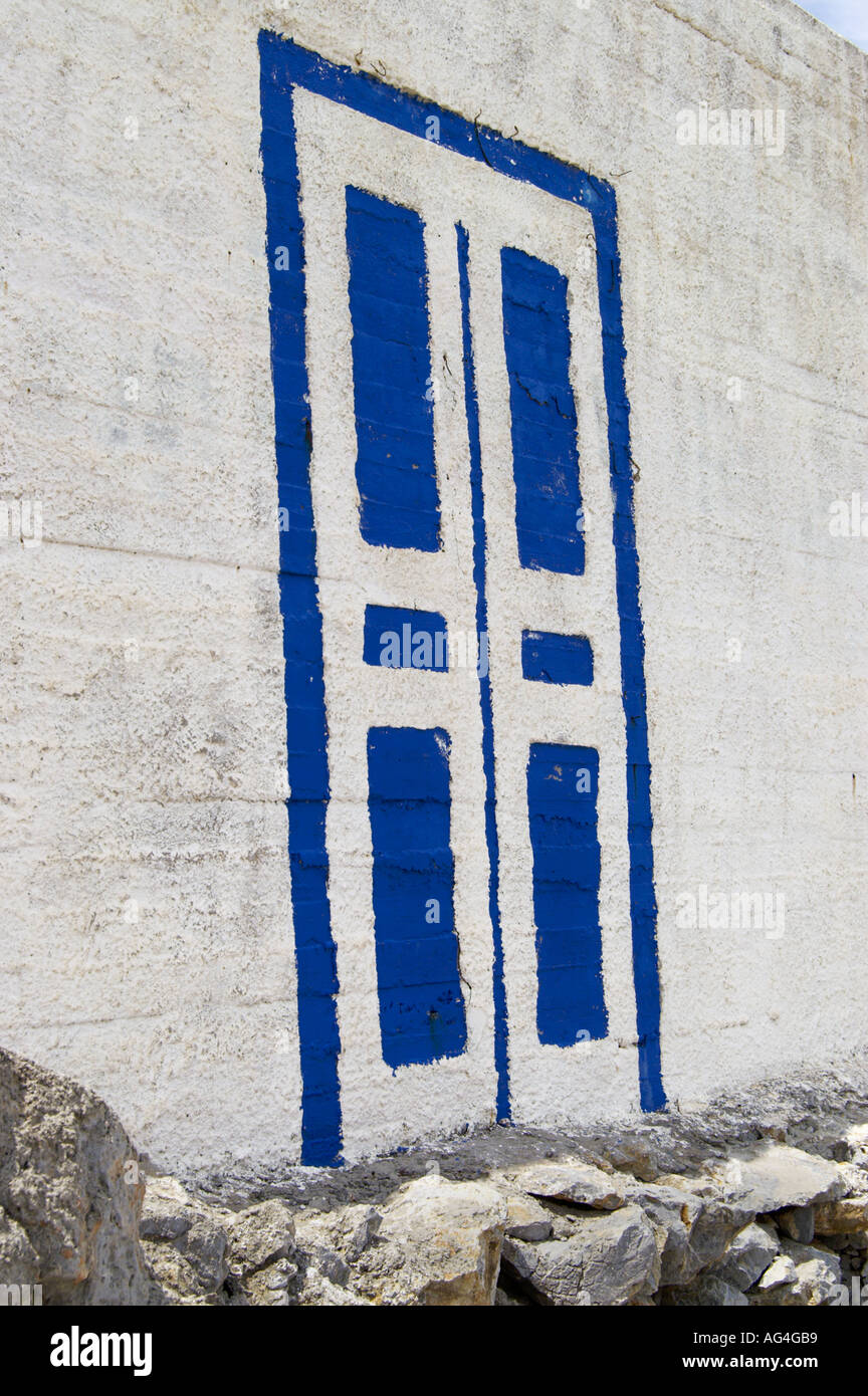 Blu e bianco finta porta dipinta sul lato di una casa su Pserimos Isole greche Foto Stock