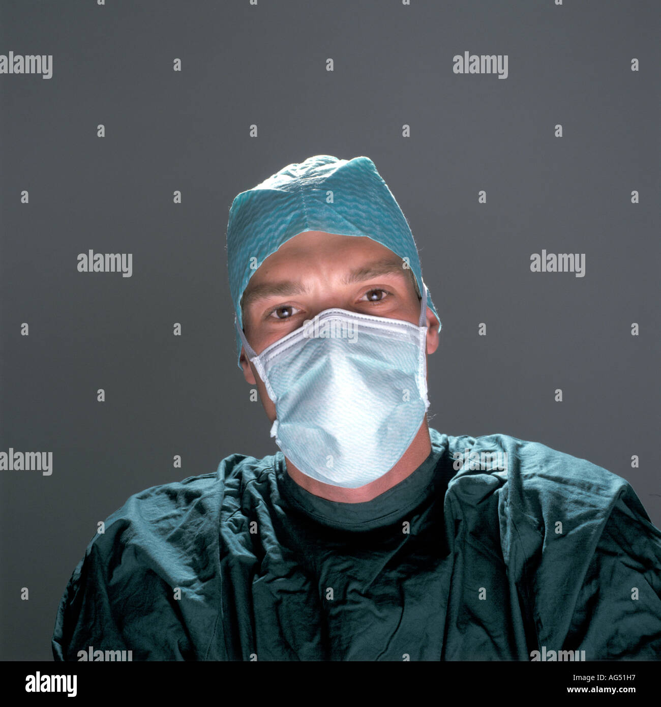 Giovane medico chirurgo che indossa la maschera per il viso e il verde di funzionamento abito di teatro Foto Stock