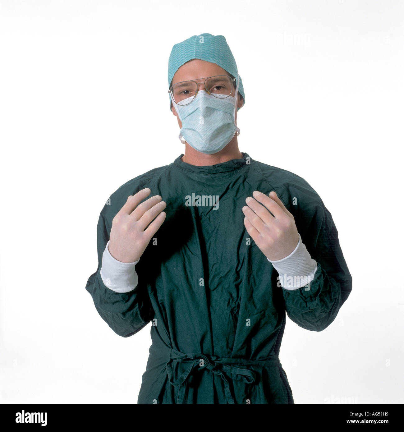 Giovane medico chirurgo che indossa la maschera per il viso e il verde di funzionamento abito di teatro Foto Stock