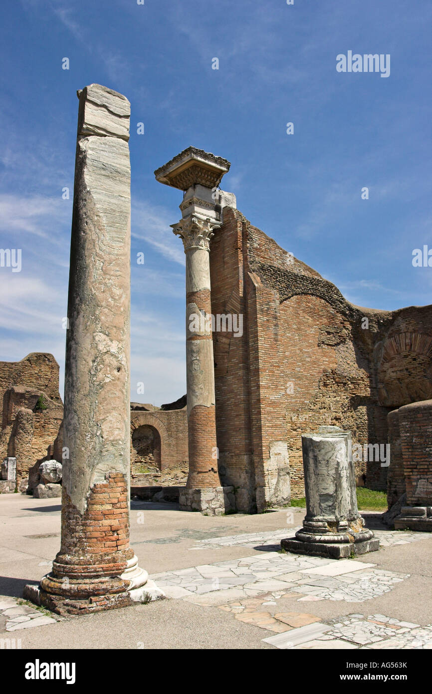 Antiche rovine -- rotture di colonne e pareti in mattoni su un pavimento di marmo facente parte del complesso di bagno di Ostia Antica Roma Italia Foto Stock