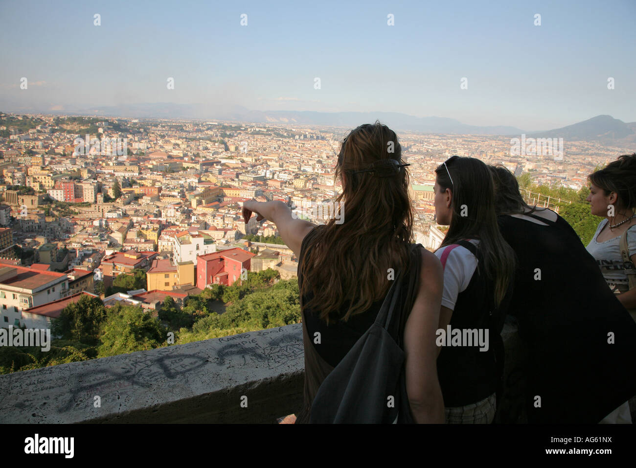 Ragazze venuti alla sommità della collina del Vomero al crepuscolo per guardare il tramonto sulla città di Napoli in Italia Foto Stock