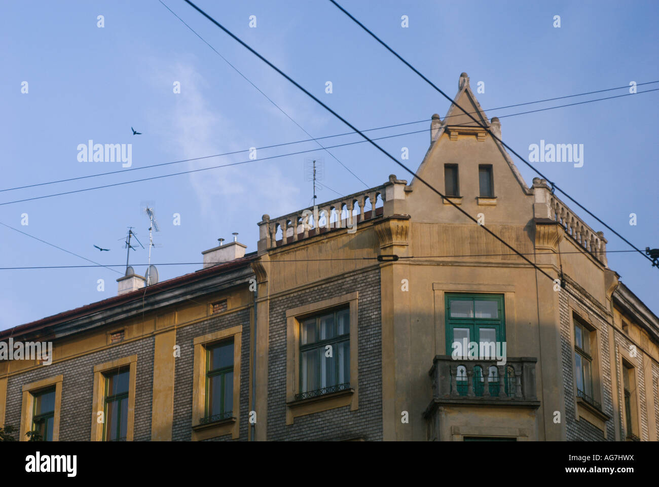 Dettagli architettonici angolo del vecchio edificio e cielo attraversato con tram linee a Cracovia Polonia Foto Stock