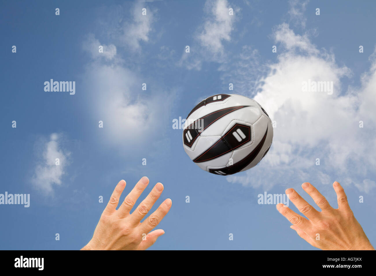 Monolocale due mani fino a raggiungere un netball in un cielo blu Foto Stock