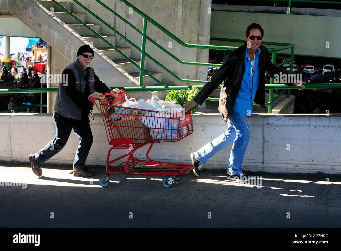 Due uomini con carrello di shopping a Flemington mercati in Sydney Australia Foto Stock