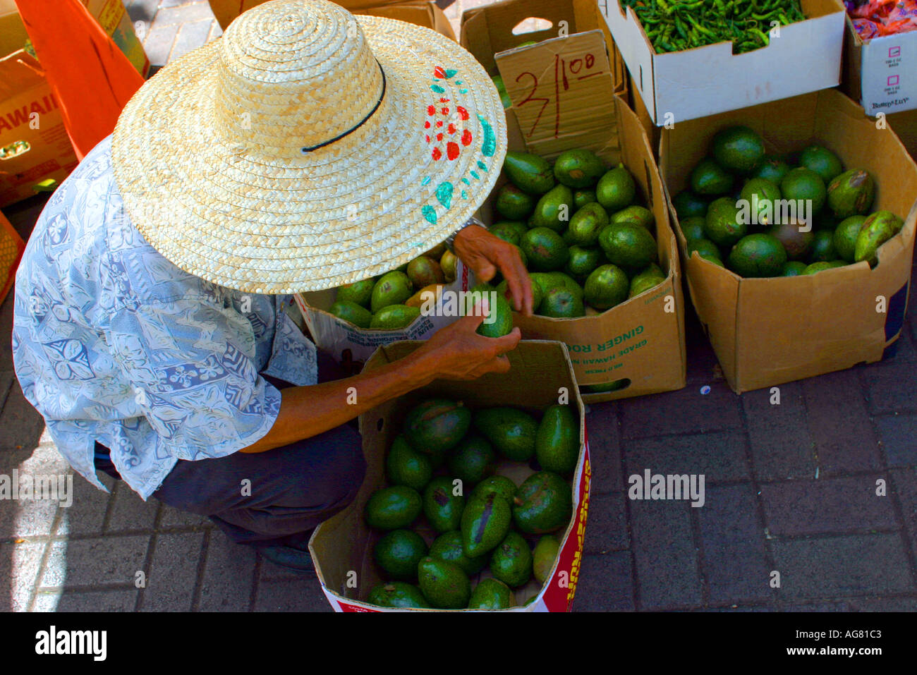 Un uomo vende frutta e verdura presso gli stand di Honolulu Hawaii presso l'Aloha Stadium swap meet. Foto Stock