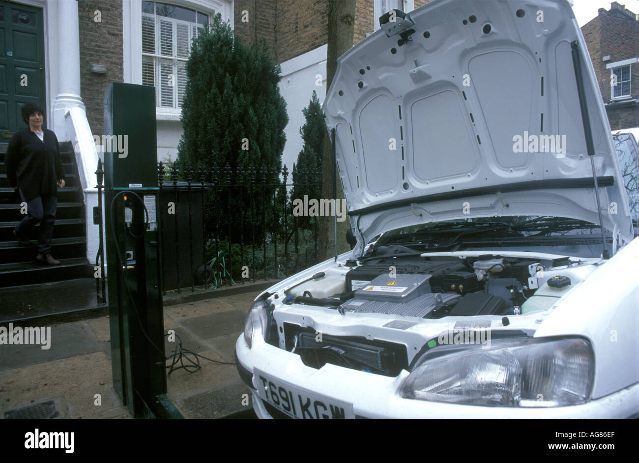 Un condotto elettricamente auto parcheggiate in una strada residenziale a Londra, Regno Unito, mentre è in fase di ricarica. 2003. Foto Stock