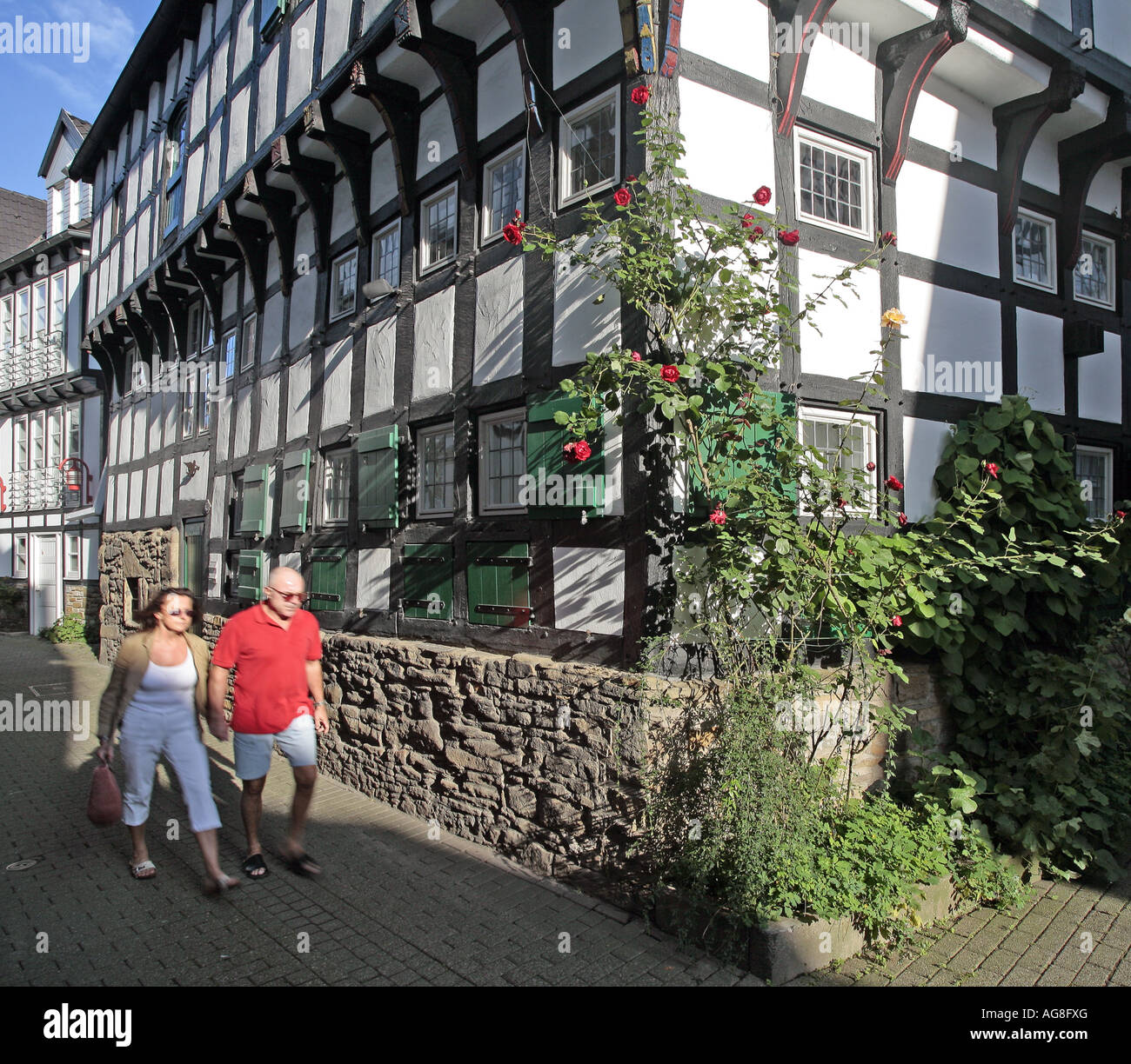 Coppia a passeggio tra case con travi di legno nel centro storico, in Germania, in Renania settentrionale-Vestfalia, la zona della Ruhr, Hattingen Foto Stock