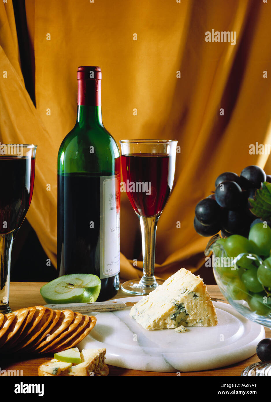 Bicchiere di vino rosso, del formaggio Stilton, bottiglia di vino e uva Foto Stock