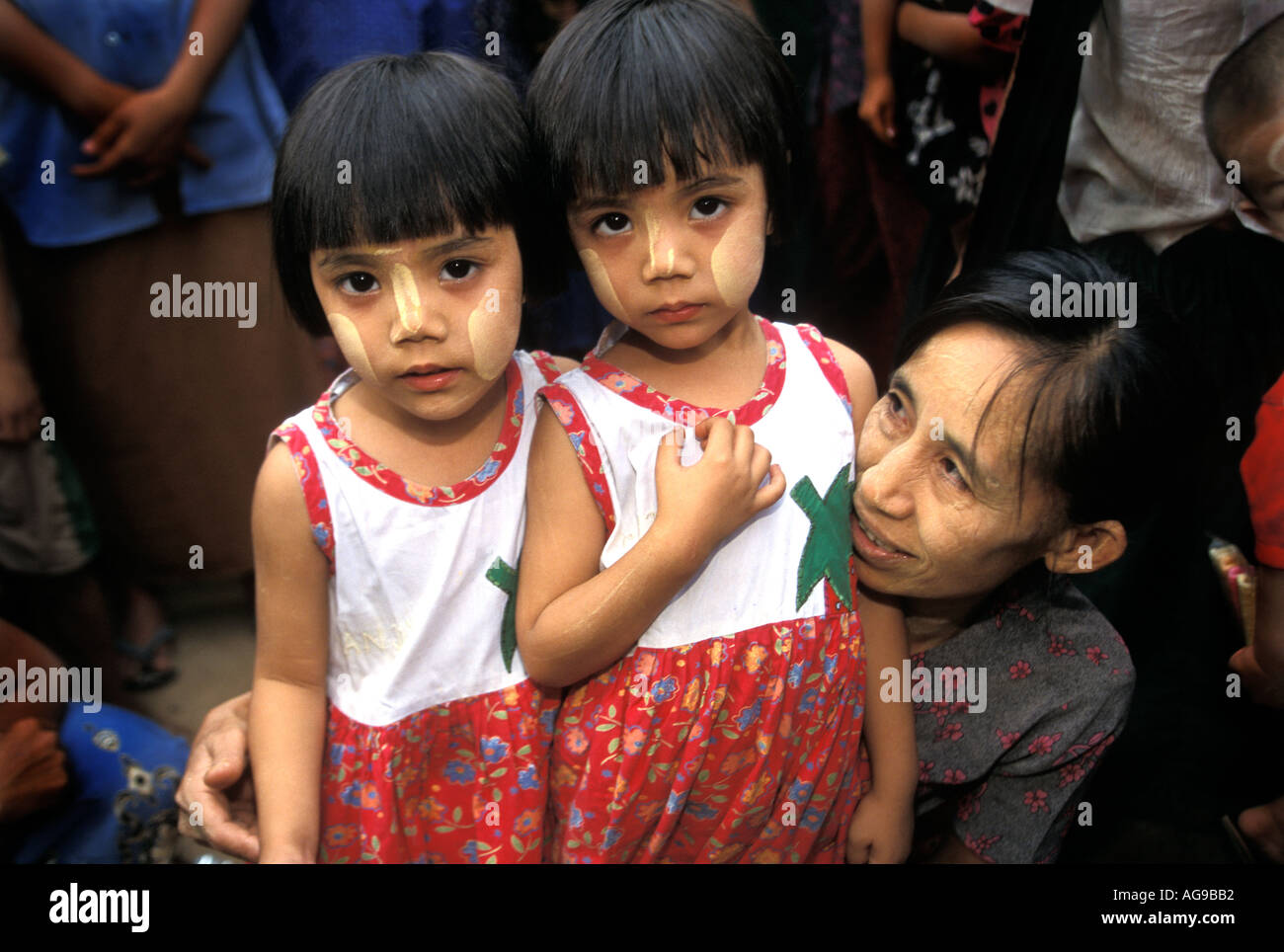 Myanmar madre con i suoi due gemelle a Nat Pwe village membro indossando il tradizionale tanaka su facce Foto Stock