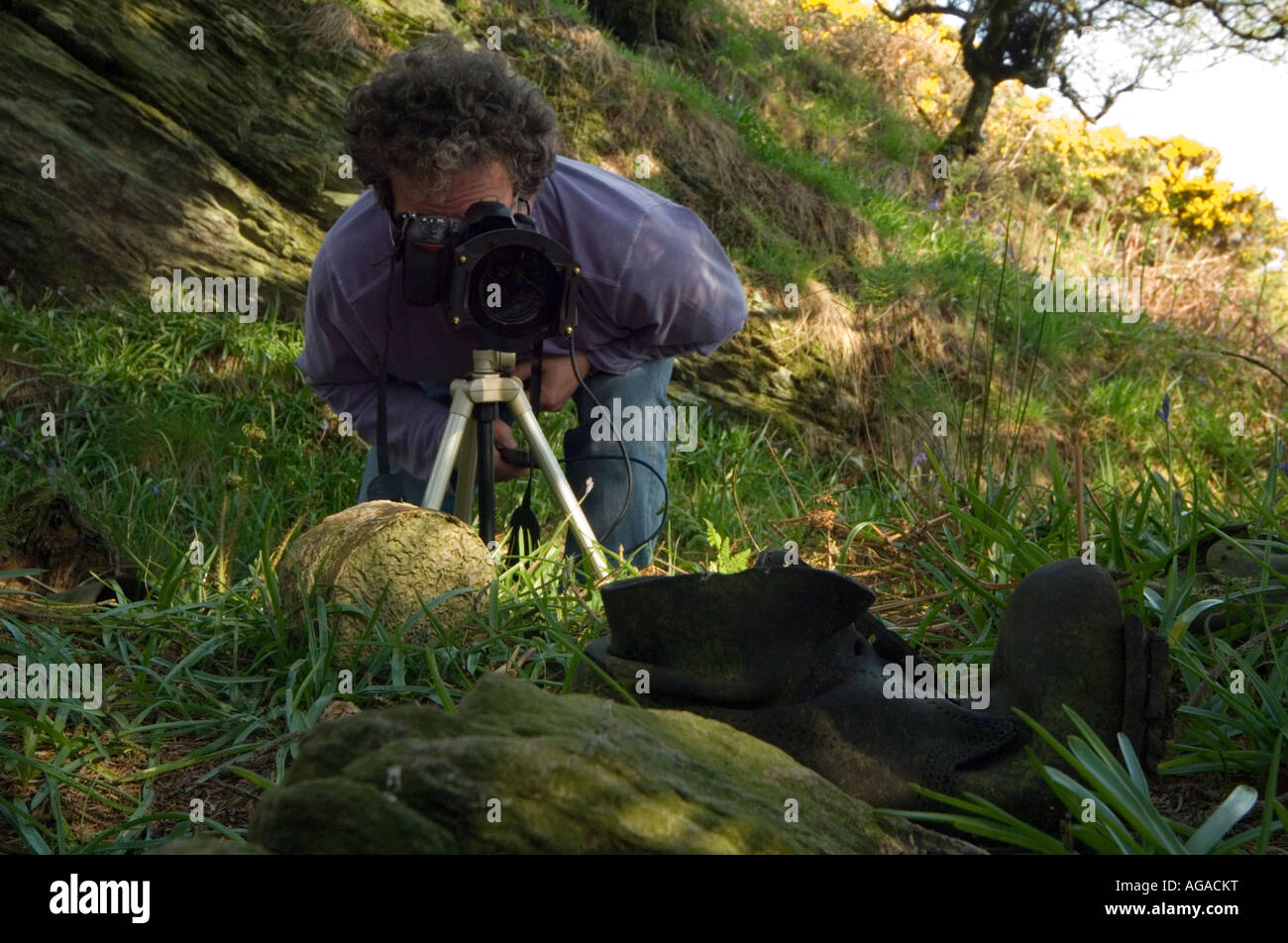 Fotografo prendendo un close up fotografia utilizzando fotocamera reflex digitale su un treppiede di un vecchio boot Foto Stock