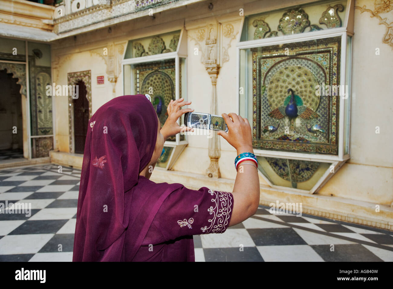 Donna indiana in splendidi sari di scattare una foto nel Complesso del City Palace in Udaipur India Foto Stock
