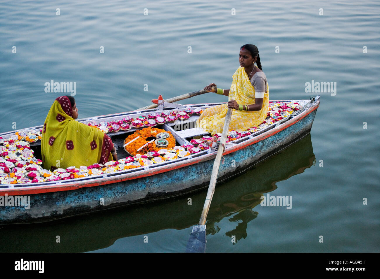 Due donna in una barca sul fiume Gange vendere deepak o lampade a olio del Fiume Gange Varanasi india Foto Stock