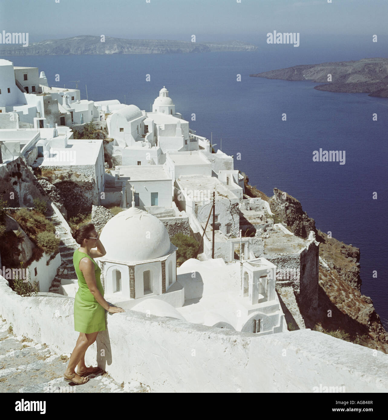 Tourist guardando la vista dalle fasi imbiancate a calce e i vicoli di Isola di Santorini, Cicladi Grecia, Egeo Foto Stock