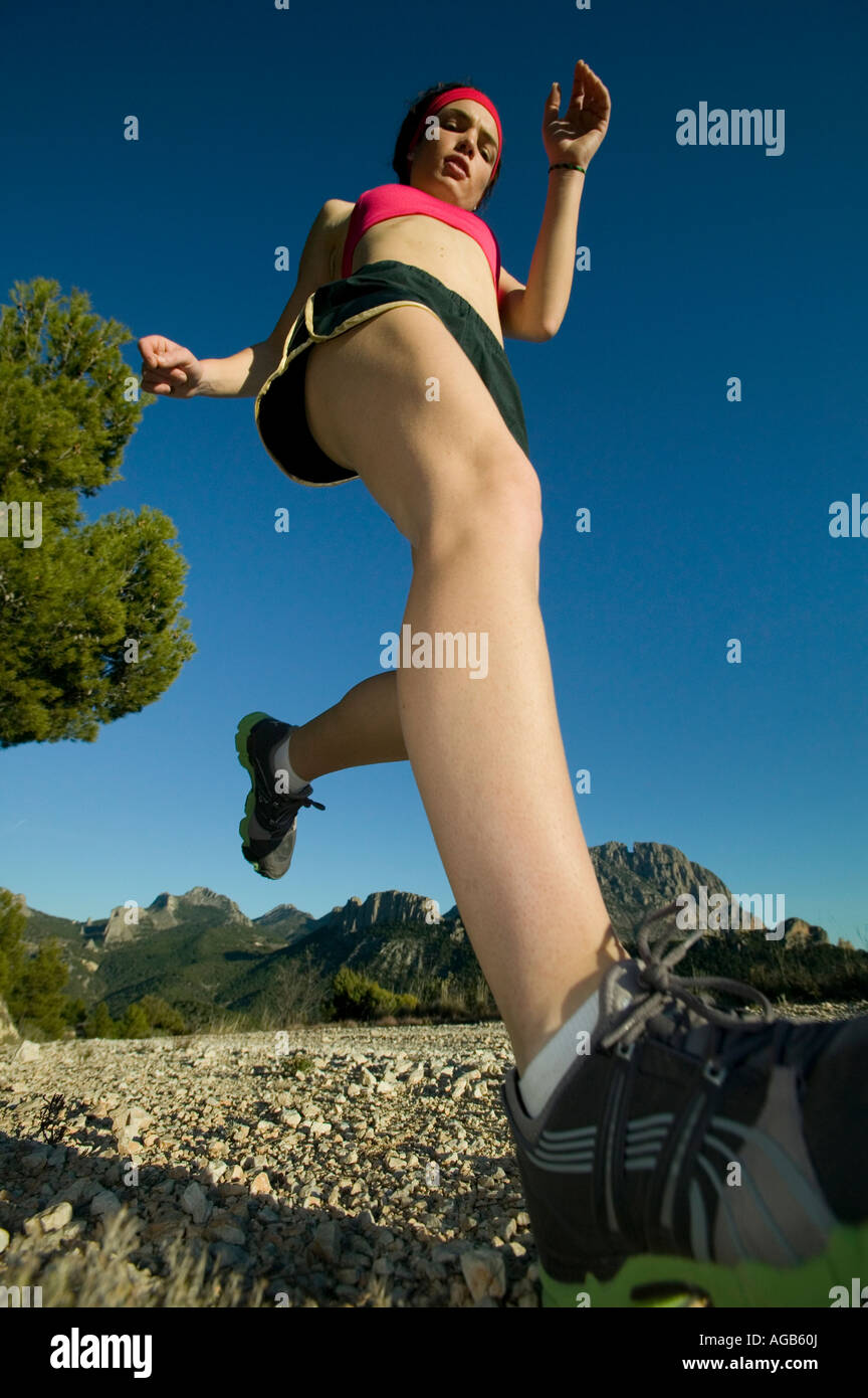 Sentiero femmina runner con sfondo di montagna Foto Stock
