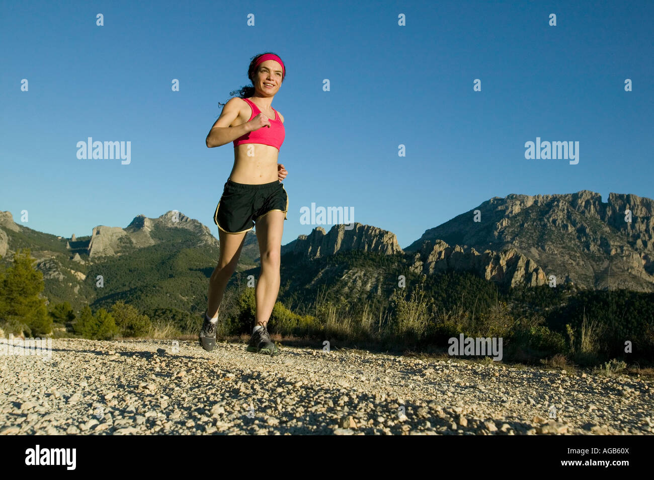 Sentiero femmina runner con sfondo di montagna Foto Stock